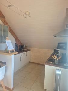 a kitchen with white cabinets and a counter top at Studio Cosy à la campagne, à 30 min des plages in Missillac