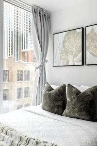 a bedroom with a window and a bed with pillows at Entertainment District Gem Walk to CN Tower in Toronto
