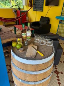 a barrel with wine bottles and glasses on a table at Chambre d'hôtes Jungle Hostel in Le Morne Rouge +19 photos