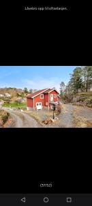 a picture of a red house next to a road at Grefstadvigveien 12 in Grimstad
