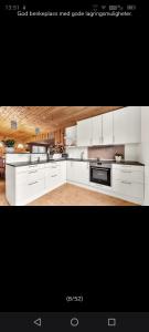 a kitchen with white cabinets and a stove top oven at Grefstadvigveien 12 in Grimstad +21 photos