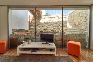 a living room with a tv and orange chairs at Views and Beds in Pontevedra