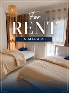 two beds in a room with a sign for rent in marhesis at Chalet with garden-marassi marina 2- Pool View in El Alamein