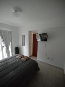 a bedroom with a bed and a flat screen tv at WB1c in Puerto Madryn