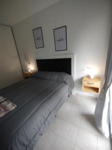 a bedroom with a bed and two pictures on the wall at WB1c in Puerto Madryn