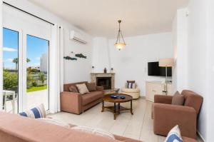 a living room with a couch and a fireplace at Amphitrite Villa in Gennadi