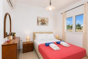 a bedroom with a bed with two towels on it at Amphitrite Villa in Gennadi +14 photos