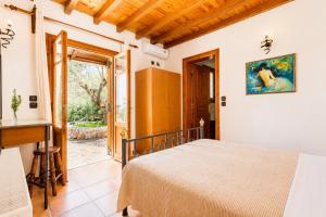 a bedroom with a bed and an open door at Villa Ioanna in Skopelos Town +10 photos