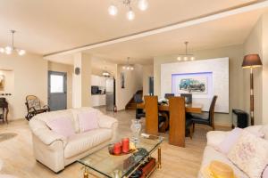 a living room with a couch and a dining room at Villa Ammos in Afantou