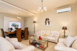 a living room with two white couches and a table at Villa Ammos in Afantou