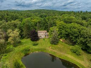 an aerial view of a house and a lake at The Whistling Oak - Pristine Pond Tranquility in Craryville