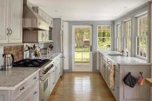a kitchen with white cabinets and a stove top oven at The Whistling Oak - Pristine Pond Tranquility in Craryville