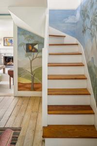 a staircase in a house with a painting on the wall at The Whistling Oak - Pristine Pond Tranquility in Craryville +28 photos