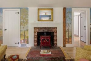 a living room with a brick fireplace with a red stove at The Whistling Oak - Pristine Pond Tranquility in Craryville