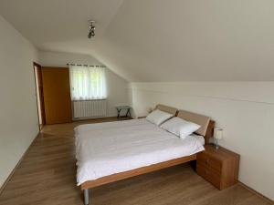 a bedroom with a large bed with white sheets at Kuća za odmor NIMA in Gospić