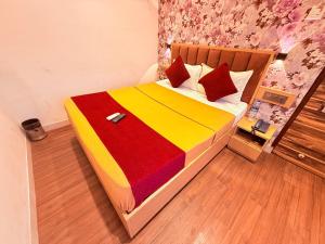 a bedroom with a bed with a colorful blanket at Hotel Iris Inn - Near Lodha Palava, Dombivali in Dombivli