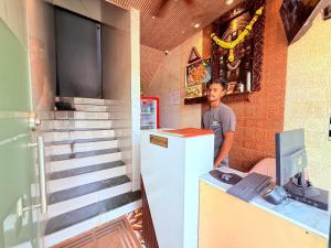 a man standing next to a counter with a refrigerator at Hotel Iris Inn - Near Lodha Palava, Dombivali in Dombivli