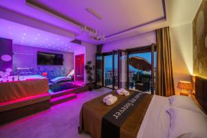 a bedroom with a bed and a tub with purple lighting at Suite Apartment Taormina in Taormina +101 photos