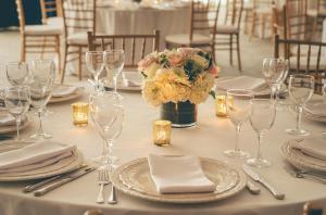 ein Tisch mit Tellern und Gläsern und einer Vase mit Blumen in der Unterkunft The Charles Hotel in Harvard Square in Cambridge