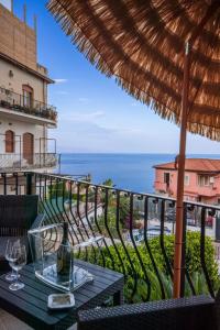 a table with a bottle of wine on a balcony at Suite Apartment Taormina in Taormina
