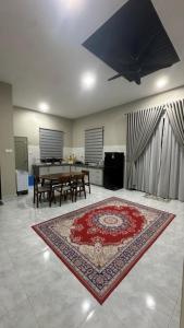 a living room with a table and a red rug at Baba Homestay in Macang