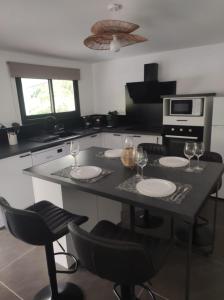 a kitchen with a table with plates and wine glasses at Villa Pauline in Les Abymes