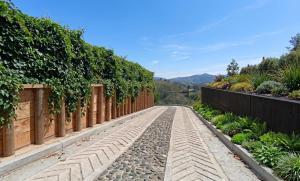 a cobblestone road in a garden with a fence at Lagoa by Loop in Horizonte