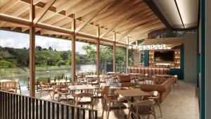 a restaurant with tables and chairs on a balcony at Lagoa by Loop in Horizonte