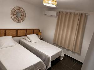 a bedroom with two beds and a mirror and a window at Villa Pauline in Les Abymes