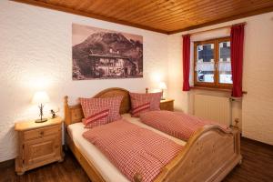 a bedroom with two beds and a window at Ferienwohnungen Alpentraum - Landhaus am Bächle in Oberstdorf