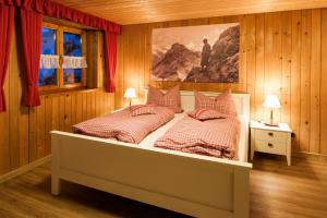 a bedroom with two beds and a painting on the wall at Ferienwohnungen Alpentraum - Landhaus am Bächle in Oberstdorf