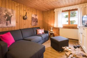 een woonkamer met een bank en een tafel bij Ferienwohnungen Alpentraum - Landhaus am Bächle in Oberstdorf