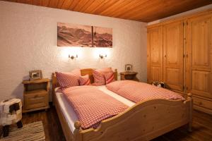 a bedroom with a bed and a wooden ceiling at Ferienwohnungen Alpentraum - Landhaus am Bächle in Oberstdorf +33 photos