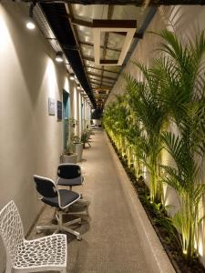 a corridor with chairs and plants in a building at GPT hostel in Hyderabad