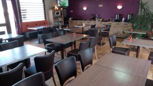 a dining room with tables and chairs in a restaurant at Hôtel Montespan in Lussac-les-Châteaux