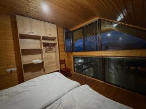 a bedroom with a bed and a large window at GomisMta-Luxury Cottage with Panor in Gomi