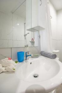 a white bathroom with a sink and a mirror at Ermira in Agios Nikolaos +9 photos