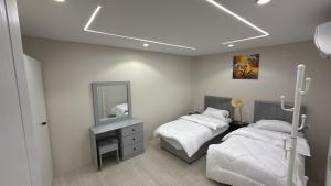 a bedroom with two beds and a mirror at الشروق in Al Baha