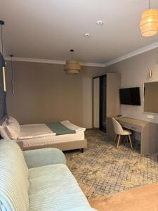 a hotel room with two beds and a desk at Benefit Boutique Hotel in Odesa