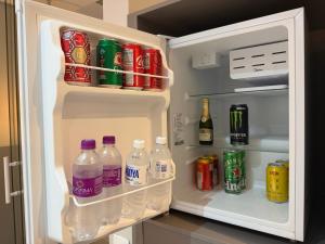 an open refrigerator filled with drinks and soda bottles at Wish Suítes in Campinas