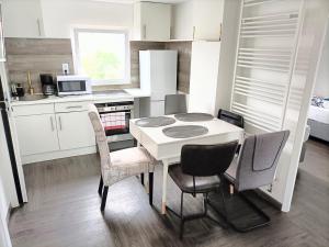 a small kitchen with a white table and chairs at Haus,Weinberg22 in Rüsselsheim