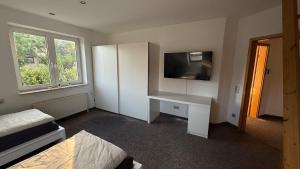 a room with a white desk with a tv on it at Private Home in Hamburg in Hamburg