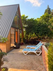 a house with two lounge chairs on a patio at Panorama Cottage in Erge