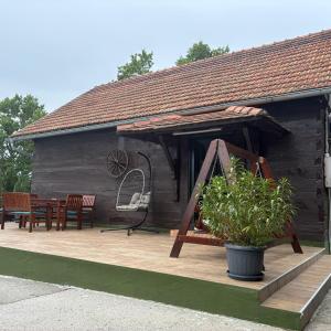 a house with a wooden deck with a table and chairs at Bajta 163 in Topusko