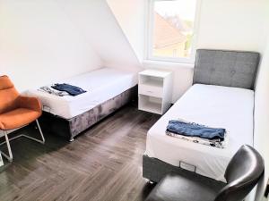 a room with two beds and a chair and a window at Haus,Weinberg22 in Rüsselsheim