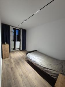 a white room with a bed and a window at The Garden Apartment in Bîrlad