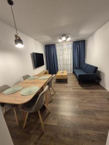a room with a table and chairs and a couch at The Garden Apartment in Bîrlad