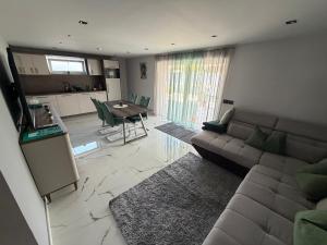 a living room with a couch and a table at Guest Apartman in Tiszakécske