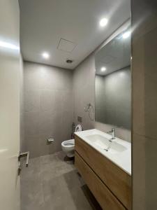 a bathroom with a sink and a toilet and a mirror at Luxury Apt l La Gare in Addis Ababa