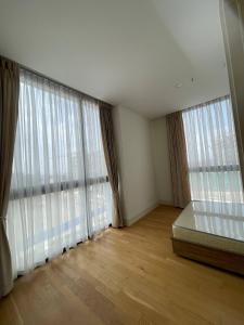 a bedroom with large windows with a bed and wooden floors at Luxury Apt l La Gare in Addis Ababa